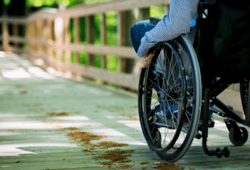 Photo libre de droits d'une personne en fauteuil roulant, de dos et sans visage visible.