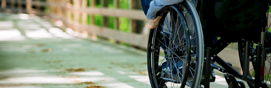 Photo libre de droits d'une personne en fauteuil roulant, de dos et sans visage visible.